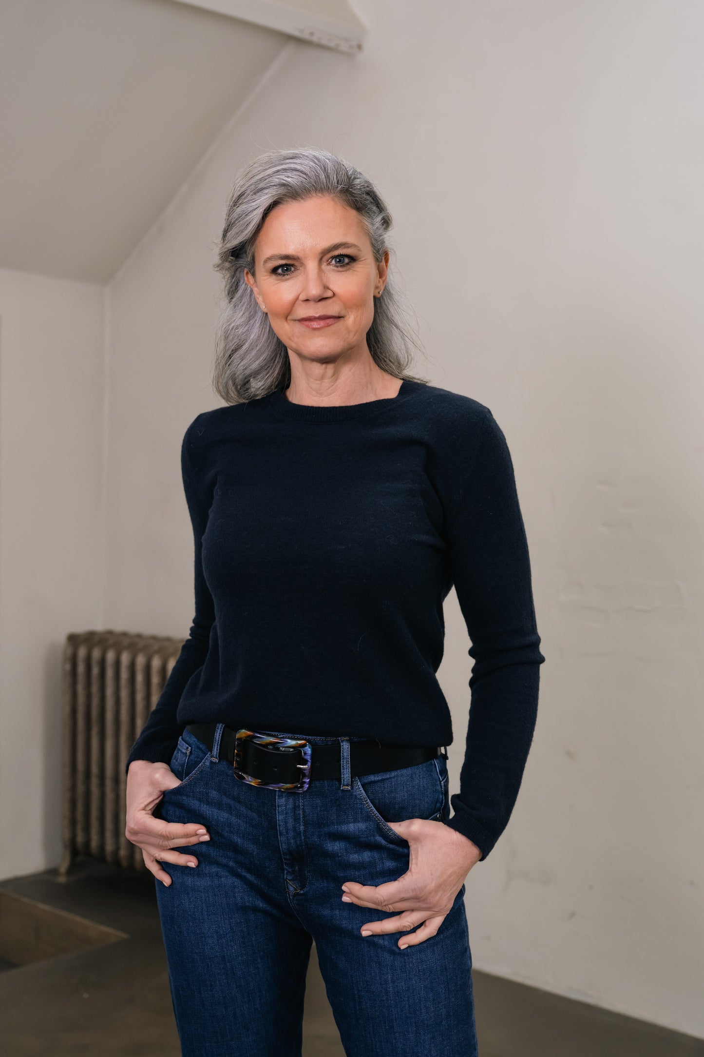 woman wears dark blue long-sleeved sweatshirt and leather belt with resin buckle