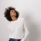 woman wears white long-sleeved sweatshirt and leather belt 