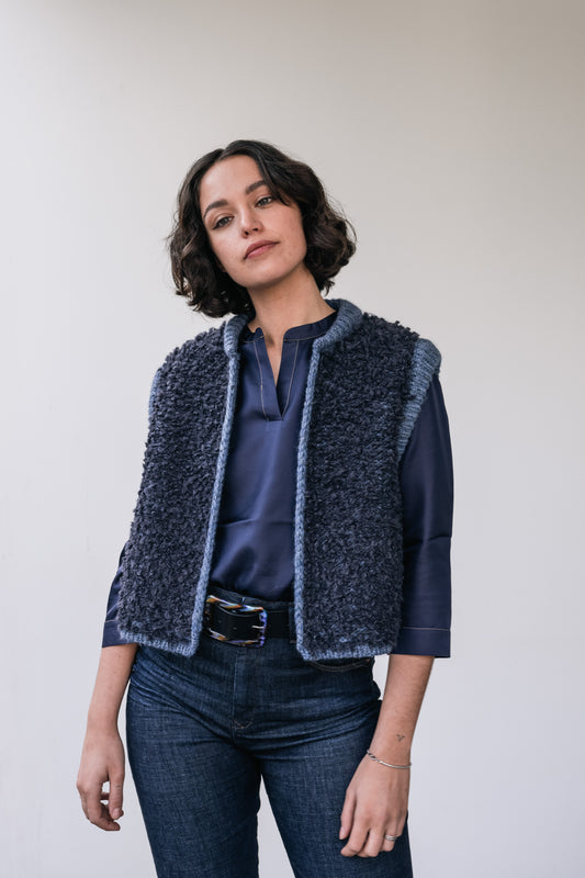 Woman wears a blue wool cardigan and leather belt with resin buckle