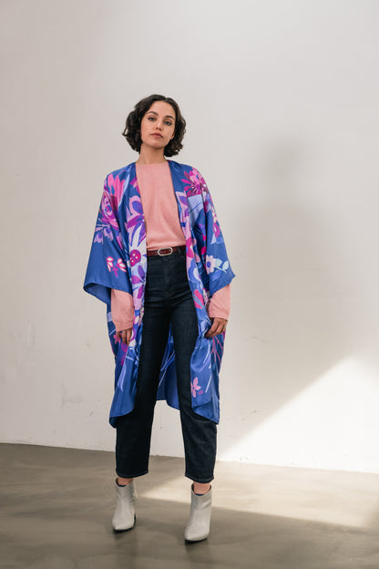 woman wears silk long kimono with blue flowers and pink sweater and small bordeaux belt