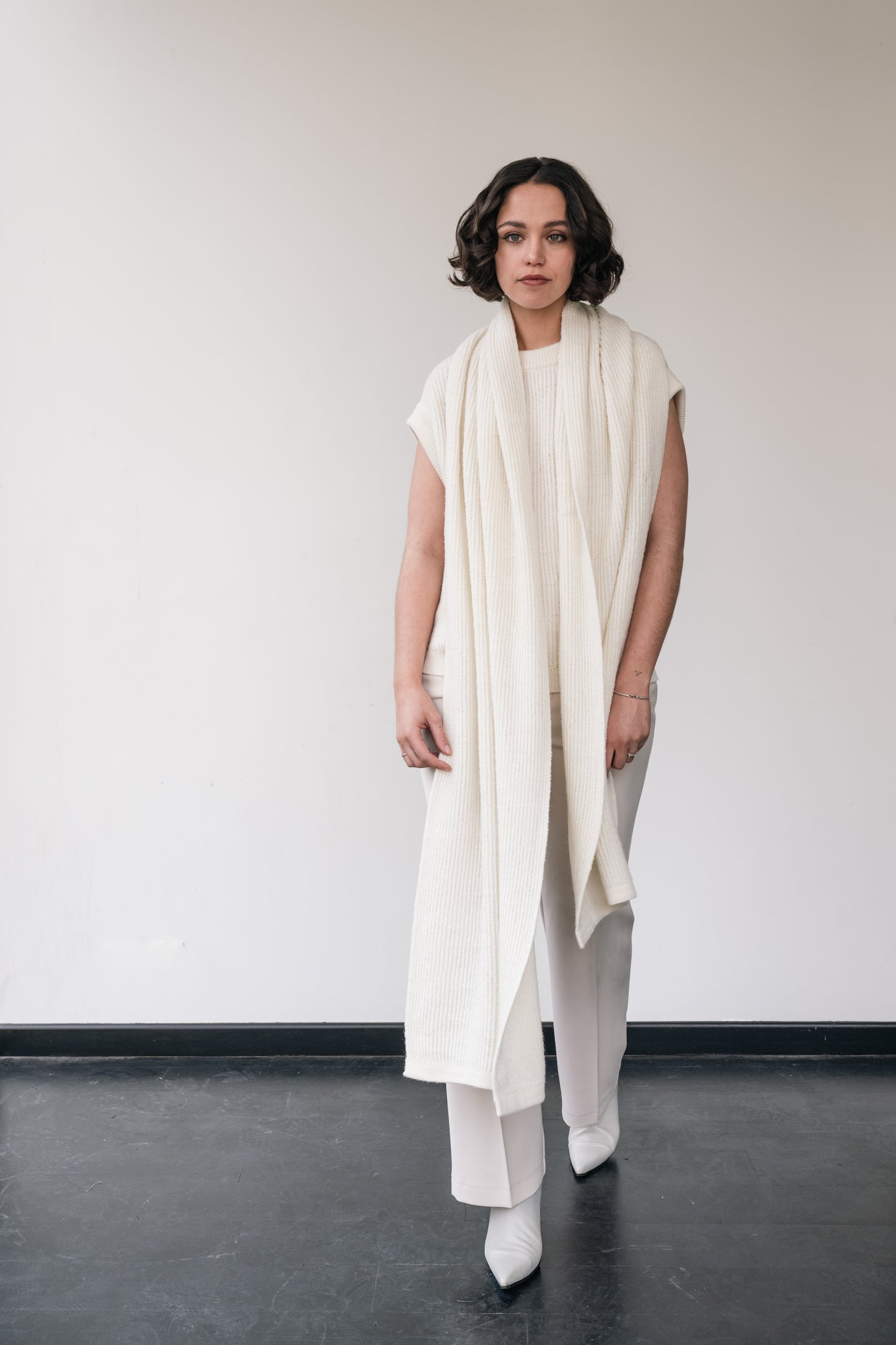woman wears white wool debardeur and white scarf