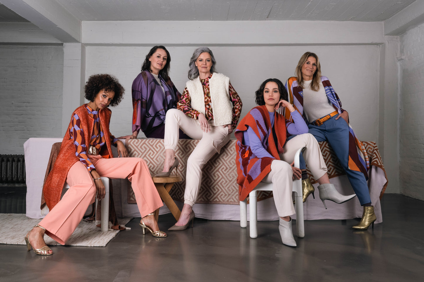 group photo of five different women. overall colors are purple and orange. Wearing different types of silk items 