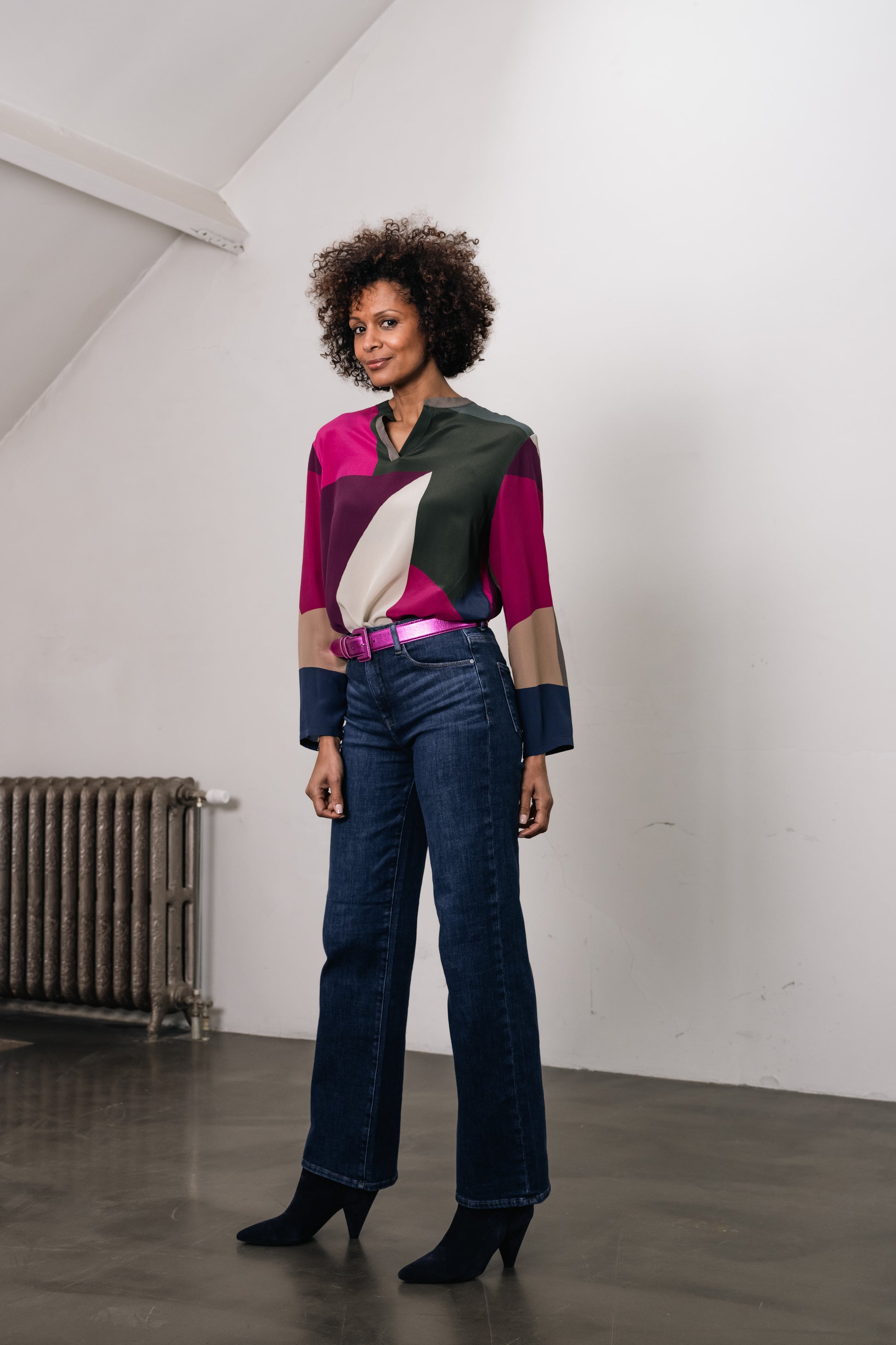 Woman wearing silk blouse and leather metallic pink belt. Main colors are fushia and green 